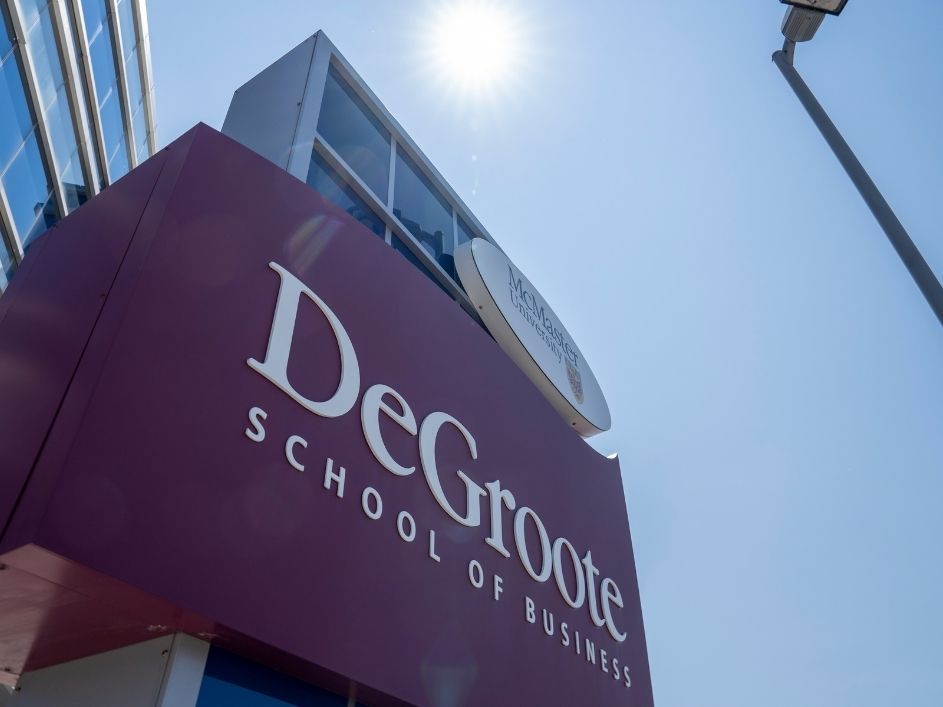 Large building sign with the DeGroote School of Business logo.