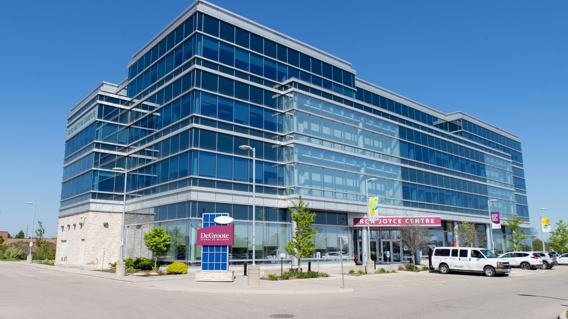 A tall glass building with a sign that reads "Ron Joyce Centre."